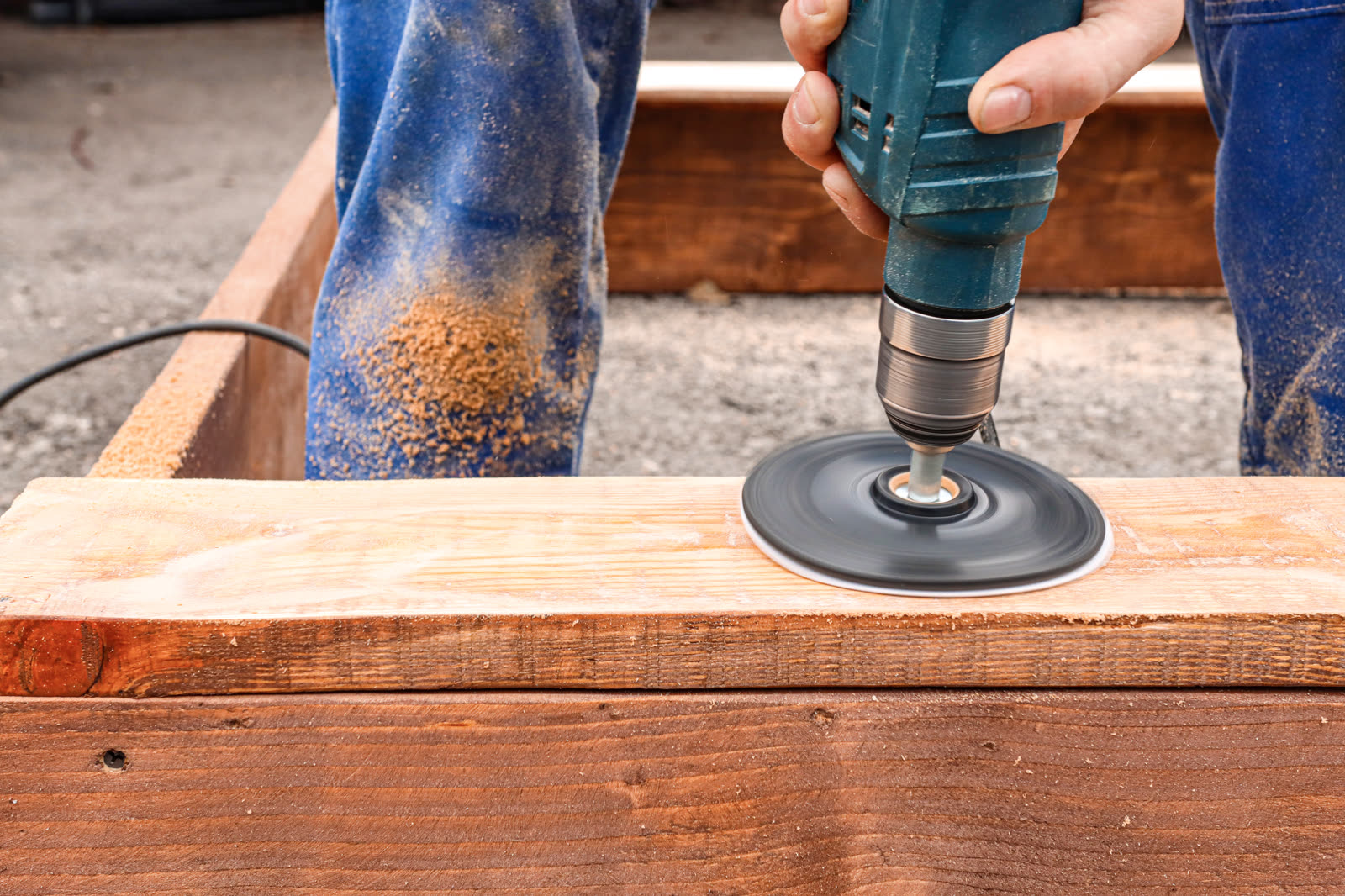 A carpenter in a blue overalls processes a wooden — the kind of handyman work vetted local pros handle in Sarasota, FL