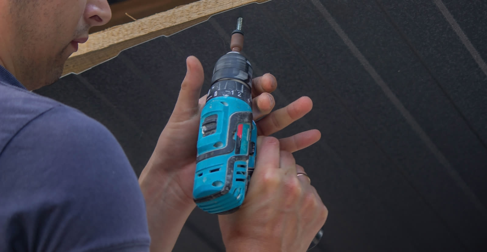 A man repairs the roof tightens the self tapping — the kind of handyman work vetted local pros handle in Sarasota, FL