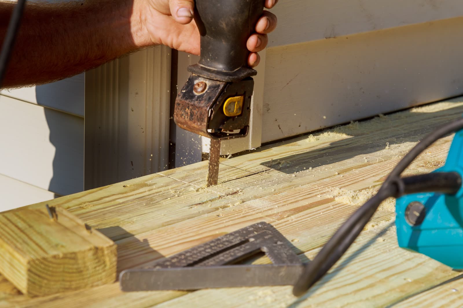 Carpenter cutting wood with electro saw constructi — the kind of handyman work vetted local pros handle in Sarasota, FL
