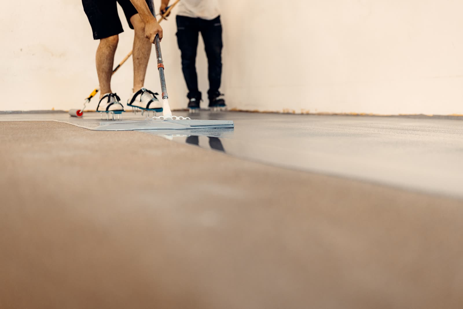 Closeup shot of worker applying floor primer with — the kind of handyman work vetted local pros handle in Sarasota, FL
