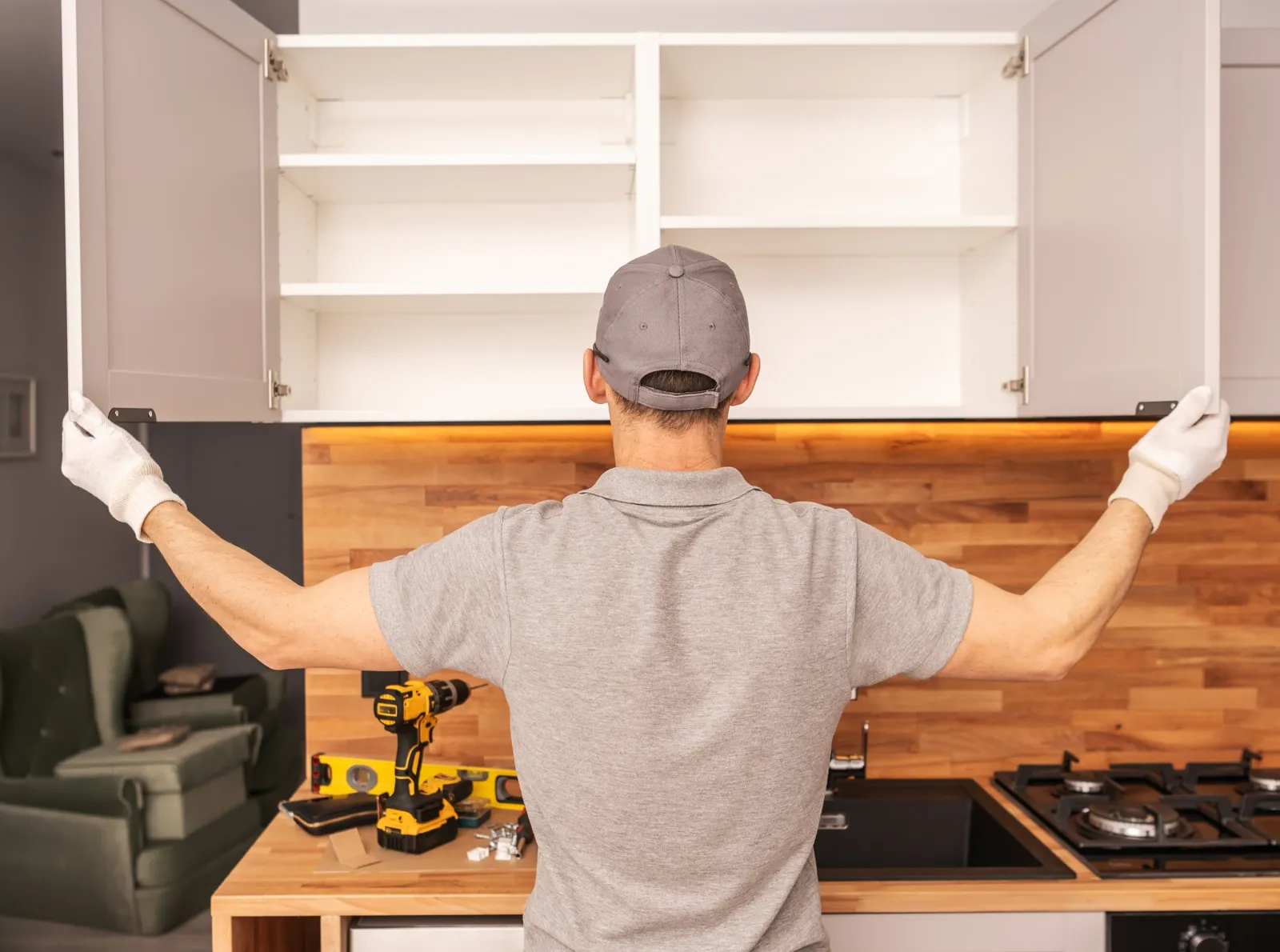 Man installing kitchen cabinets in a modern home — the kind of handyman work vetted local pros handle in Sarasota, FL