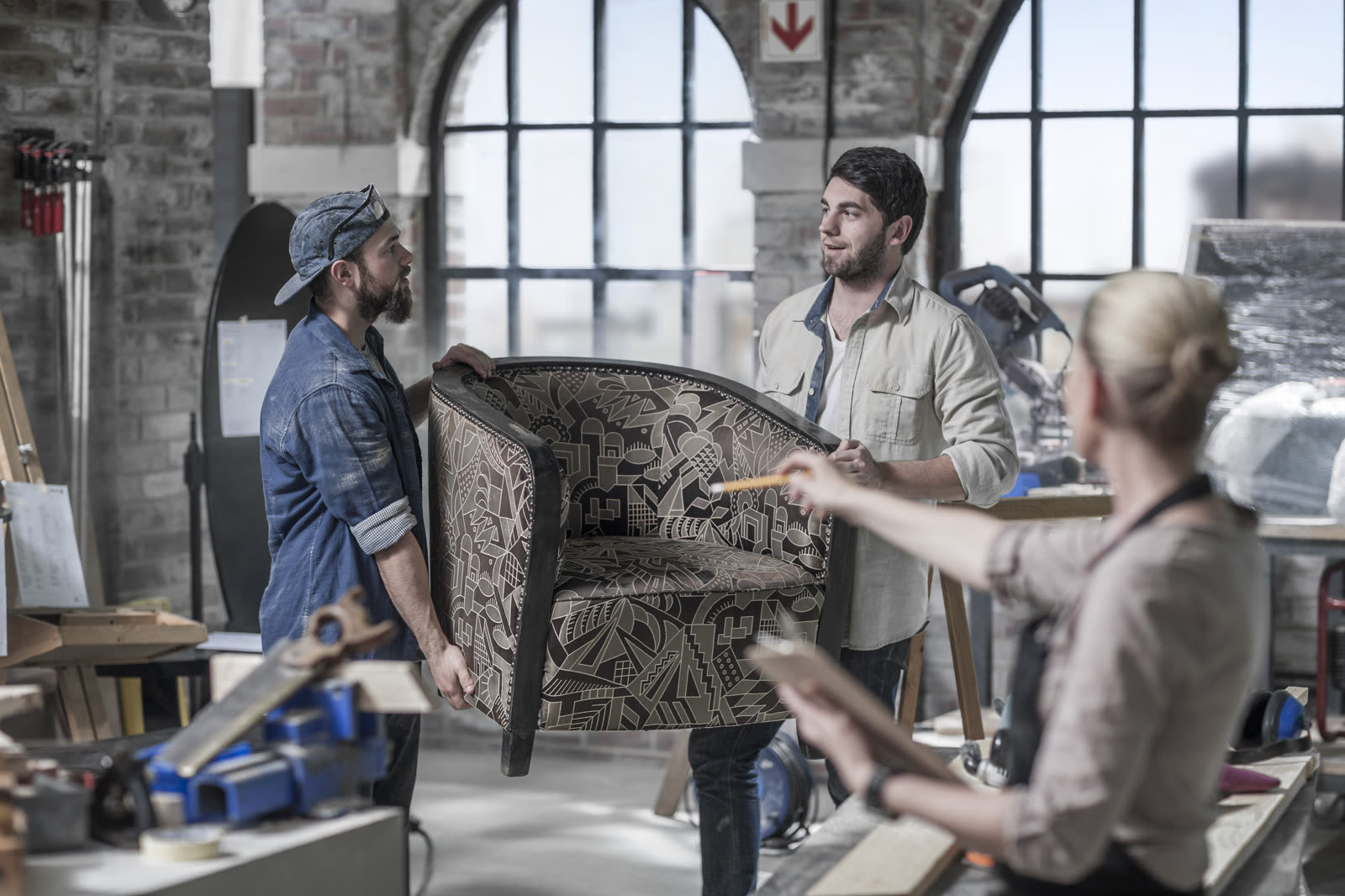 Manager directing male workers carrying armchair i — the kind of handyman work vetted local pros handle in Sarasota, FL