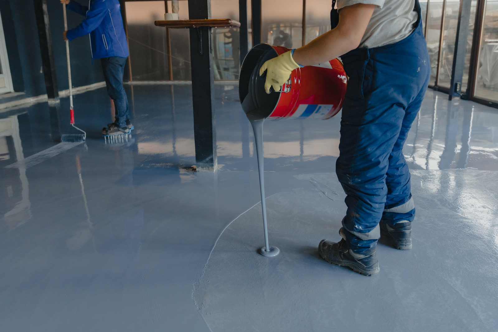 The worker applies gray epoxy resin to the new flo — the kind of handyman work vetted local pros handle in Sarasota, FL