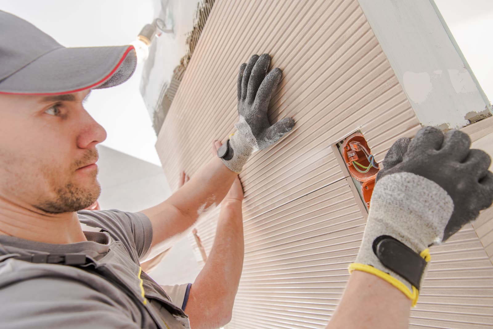 Worker installing large tile — the kind of handyman work vetted local pros handle in Sarasota, FL