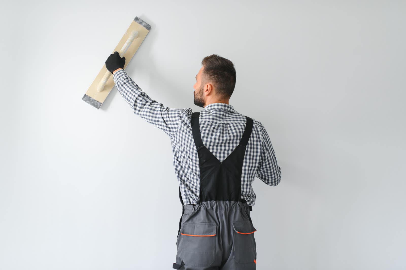 Young worker making repair in room — the kind of handyman work vetted local pros handle in Sarasota, FL