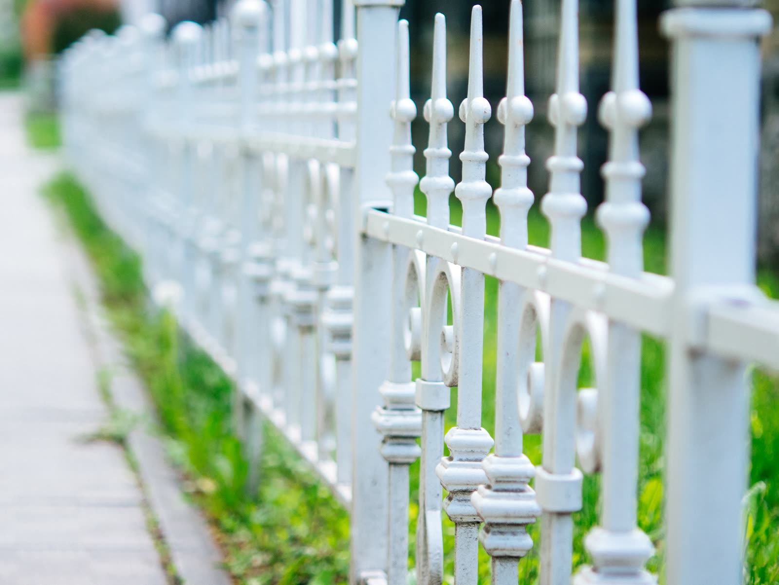 White picket fence along a sidewalk