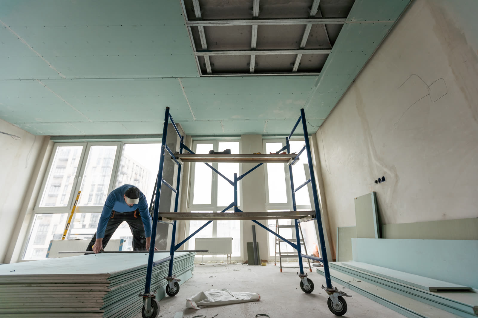 Ceiling drywall work from a rolling scaffold
