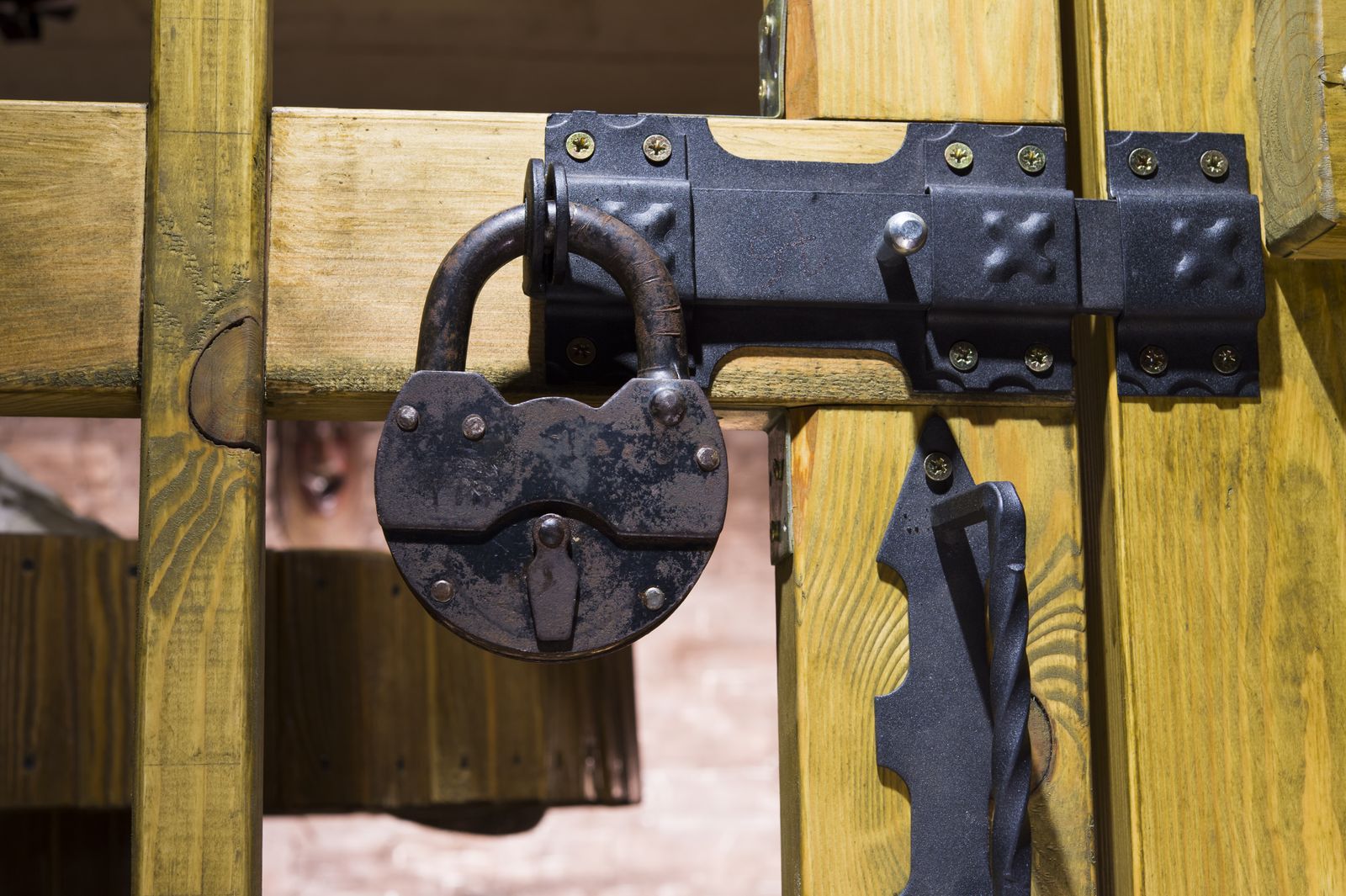 Antique lock and latch securing wooden gate — the kind of handyman work vetted local pros handle in Sarasota, FL