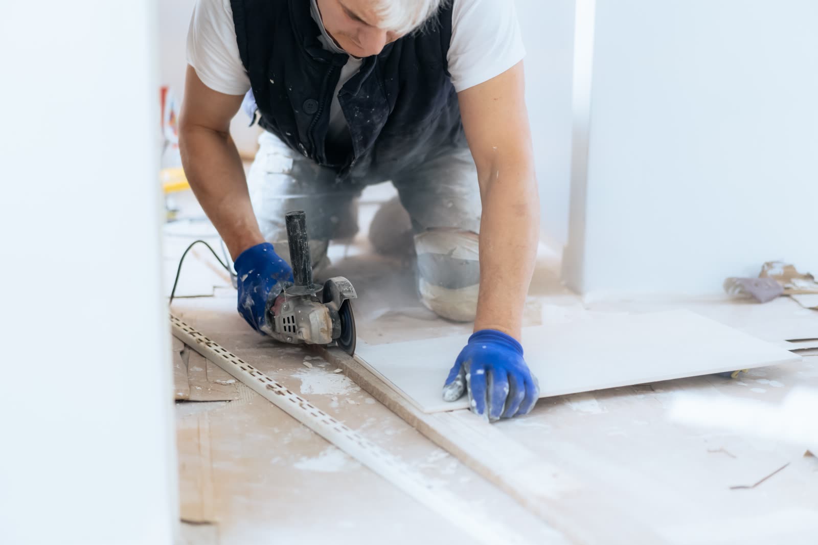 Male builder cuts tiles with special equipment — the kind of handyman work vetted local pros handle in Sarasota, FL