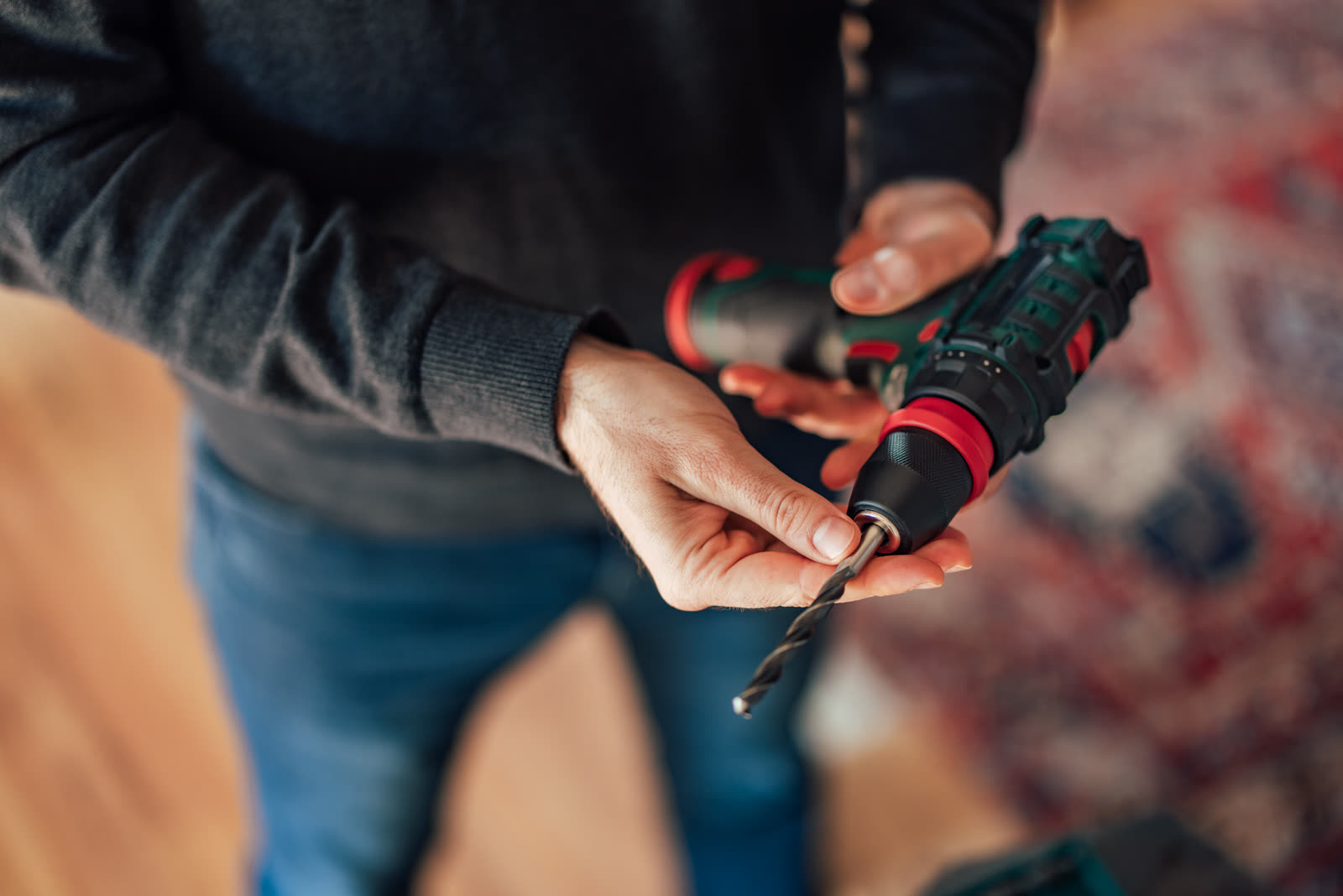 A man standing and holding a drill with a drill bi — the kind of handyman work vetted local pros handle in Sarasota, FL